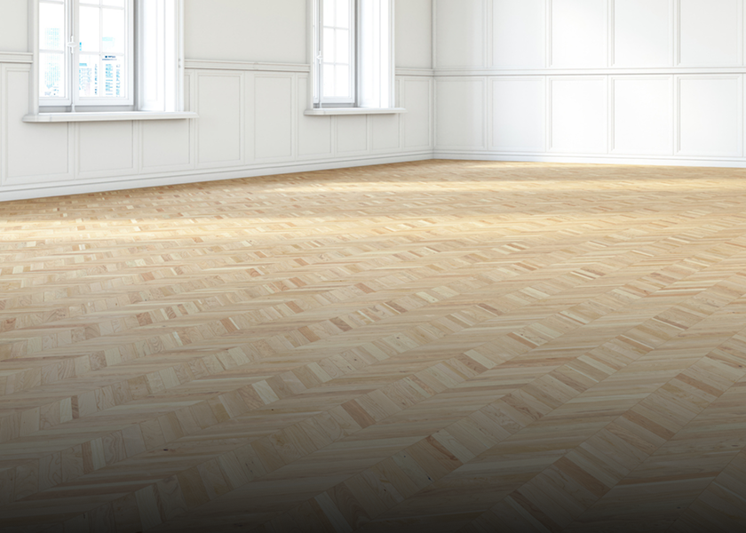 Empty room with wooden parquet flooring and white walls.