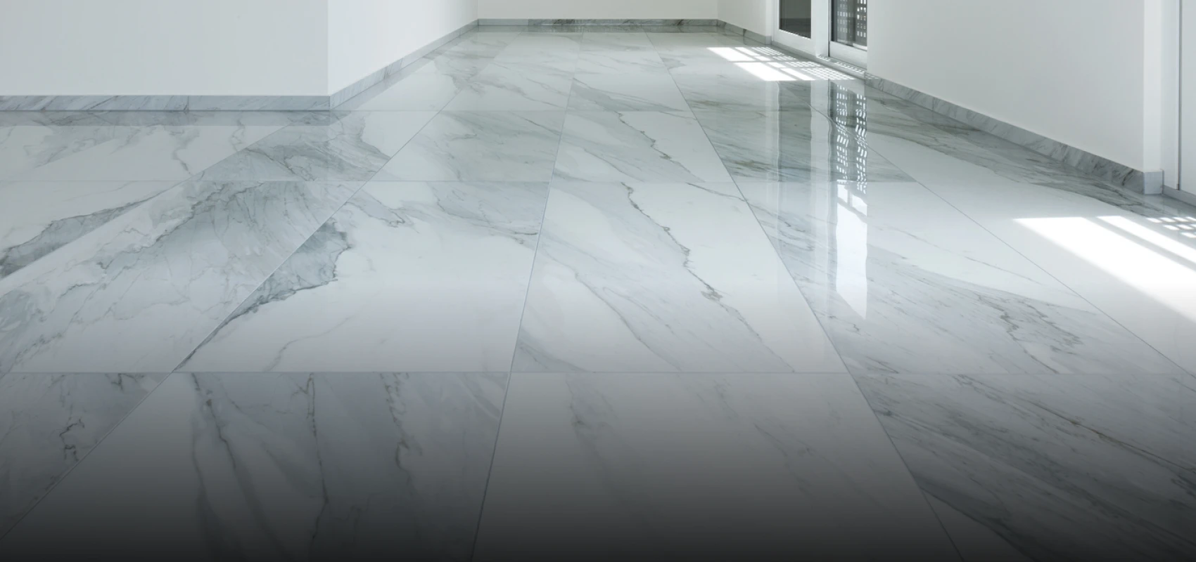 Polished white marble floor with subtle gray veining in a bright room.