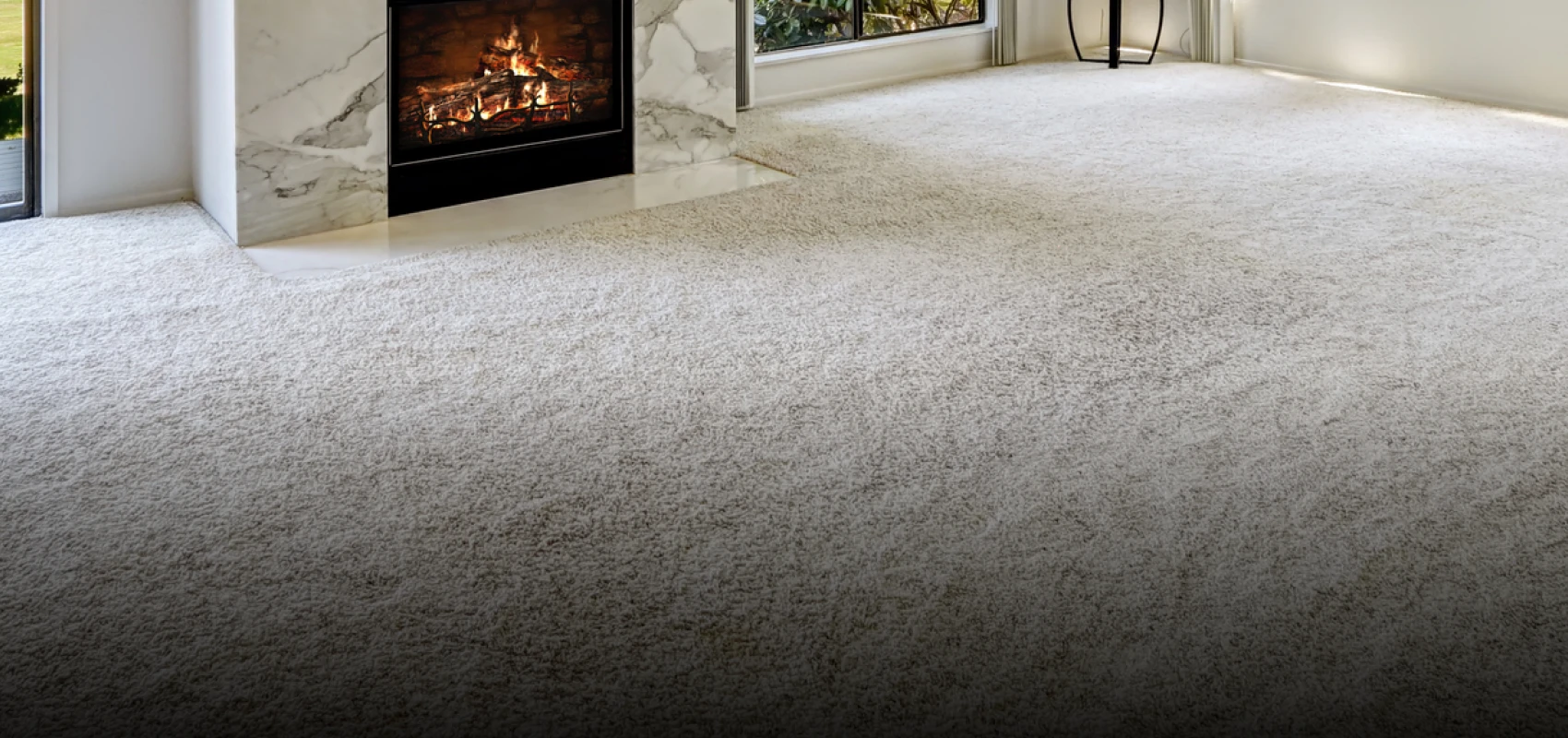 Cozy room with plush carpet and a warm fireplace.