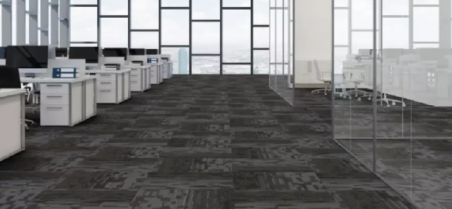 Modern office space with dark patterned carpet and glass partitions.